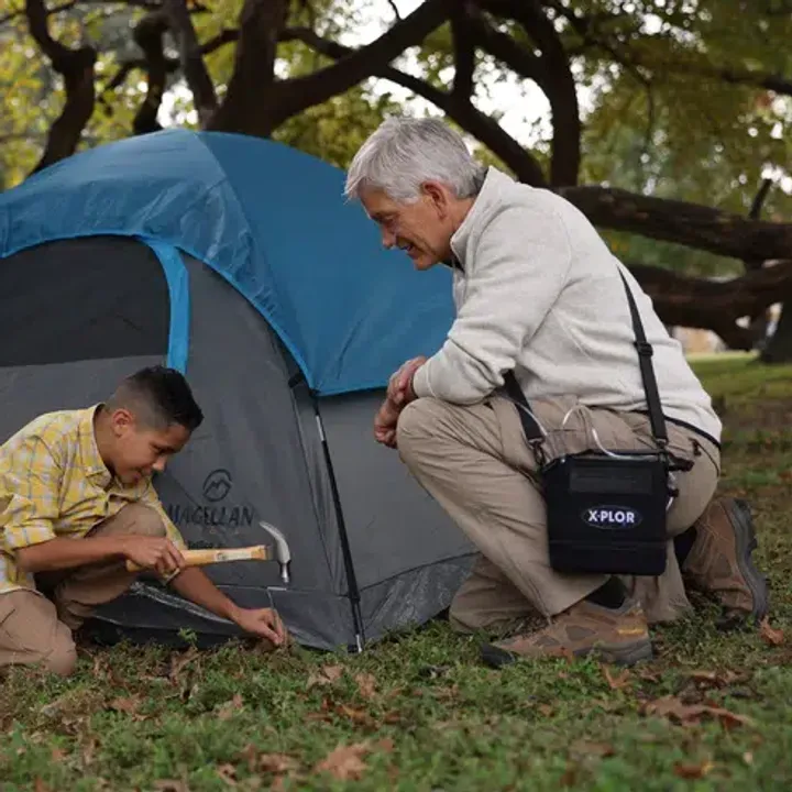 A man hiking outdoors while using a lightweight portable oxygen concentrator