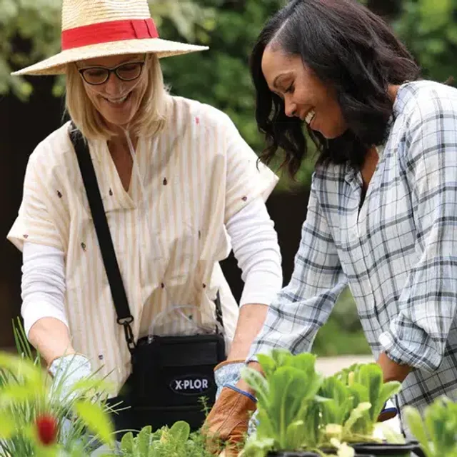 A woman gardening comfortably while using a portable oxygen concentrator